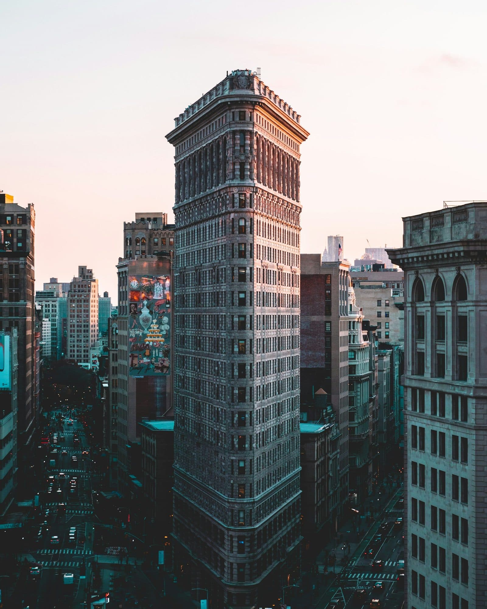 The Flatiron Building at dusk, seen from above, with traffic on Fifth Avenue and Broadway